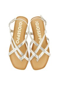 Sandalias plateadas de tiras con tiras metálicas cruzadas, suela plana color marrón y hebilla ajustable en el tobillo; logo de la marca visible en la plantilla.