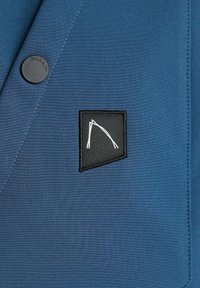 Plavi sako od tkanine sa crnim kvadratnim krpom s bijelim apstraktnim dizajnom i okruglim crnim dugmetom sa natpisom "CHASIN."