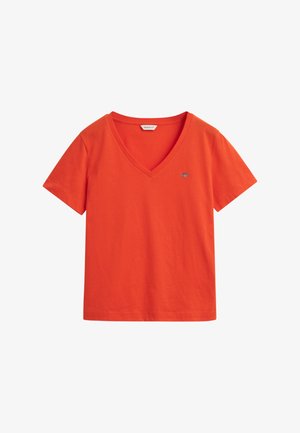 T-shirt en coton orange avec un col en V, des manches courtes et un petit logo sur la poitrine. Design simple et décontracté.