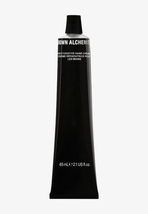 Tube de crème pour les mains noir en métal avec un col effilé, affichant un texte blanc pour le branding et les détails du produit, 65 mL / 2,1 oz fl US.