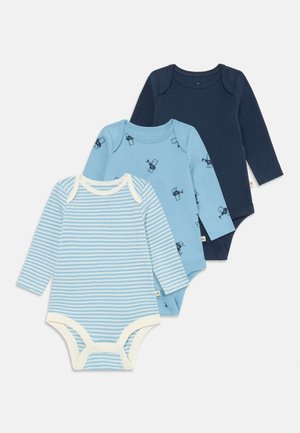 Trois bodies à manches longues pour bébés en bleu marine, en bleu clair avec un motif d'ours, et en bleu clair avec des rayures blanches et des finitions, posés à plat.