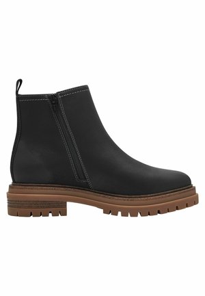 Botines negros de cuero suave con cremallera lateral, contrastados con una suela de goma marrón texturizada y detalles de costura blanca.