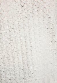 Weißer Strickpullover mit einem komplexen Rautenmuster, offenen Strickabschnitten und geripptem Saum. Weiche Textur und leichtes Gewicht.