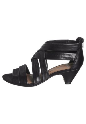 Zwarte leren sandaal met gekruiste banden, open teen en een lage kegelhak. Beschikt over een gecorrigeerde binnenzool voor comfort en een zijrits voor gemakkelijke aandoen.