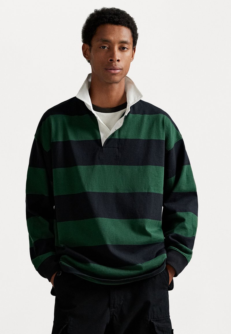 Groen en zwart gestreepte rugbyshirt met een witte kraag, voorzien van een knoopsluiting bij de hals en een relaxed fit, gemaakt van katoen.