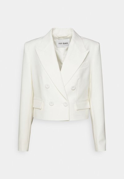 Veste croisée courte blanche. Présente un revers en pointe, deux poches avant et des fermetures à boutons, fabriquée en tissu structuré.