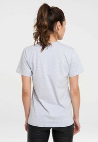 Gray T-shirt made from cotton blend. Short sleeves, crew neck, and smooth texture. Visible stitching detail along the hem.