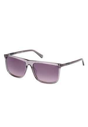 Lunettes de soleil grises avec des verres carrés, teinte dégradée violette. Monture en plastique transparent avec un détail de logo subtil sur la branche, texture lisse.