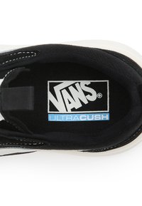 Interno nero di una scarpa Vans, con il logo bianco "VANS" sopra la parola "ULTRACUSH" in blu, circondato da una fodera nera testurizzata.