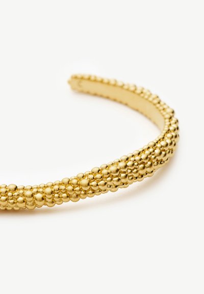 Armreif aus Metall in Goldoptik mit Clustern polierter runder Perlen entlang der gewölbten Oberfläche.