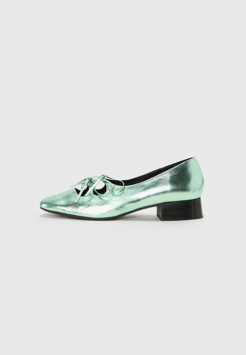 Miętowo-zielone metaliczne buty o spiczastym czubku, z detalem w postaci kokardy i niskim czarnym blokowym obcasie. Gładka tekstura i elegancki design.