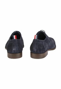 Marineblaues Wildleder mit runder Form, mit einem niedrigen braunen Absatz und rot-weiß-blauen gestreiften Akzenten an den Absatzlaschen.