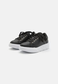 Black leather sneakers featuring a white rubber sole, round toe, and gold eyelets with black laces. Smooth texture with a cushioned sole.