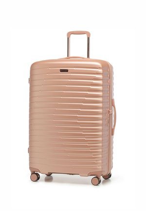 Maleta rígida en color rosa dorado, con un diseño estriado, asa retráctil y cuatro ruedas giratorias para facilitar la movilidad.