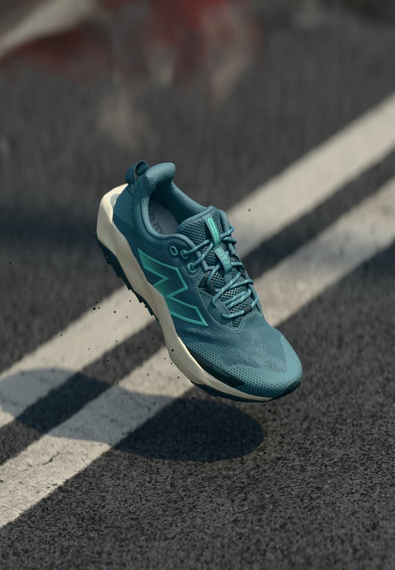 Türkiissinine spordijalats tekstureeritud võrkmaterjalist pealiskihiga, valge kummist tallaga ja nurkadega aktsentidega. Omab paelu ja polsterdatud kaelust.