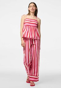 Completo a due pezzi composto da un top peplum a righe rosa e rosse con spalline sottili e pantaloni a gamba larga a righe. Tessuto strutturato con una vestibilità rilassata.