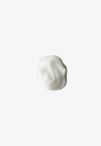 Crema bianca e soffice con una consistenza morbida e liscia, sagomata in modo irregolare con dolci onde e pieghe, appoggiata su uno sfondo chiaro.
