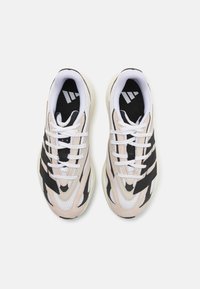 Sneakers with a mesh and suede upper in beige and white, featuring black stripes and white laces. Rubber outsole with textured detailing.