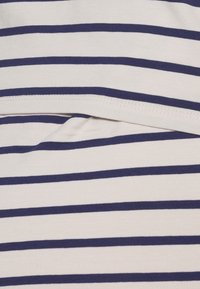 T-shirt i bomull med vita och marinblå horisontella ränder, med en mjuk textur och en klassisk rund halsringning.