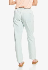 Pantalones jogger de algodón verde menta claro con cintura elástica, dos bolsillos traseros y un corte relajado. Textura suave y diseño de pierna recta.