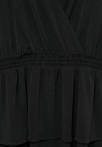 Robe en tissu noir avec taille élastique froncée et design portefeuille à col en V, avec des plis inférieurs doux et fluides.