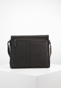 Borsa a tracolla in pelle nera con un design piatto, chiusura superiore con zip, tracolla regolabile e tasca frontale; texture liscia con accenti minimi.