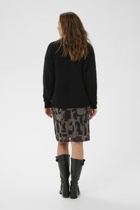 Sort striktrøje, mønstret blyantskirt i grå og sorte nuancer, knæhøje sorte læderstøvler med spænder. Tekstureret, afslappet ensemble.