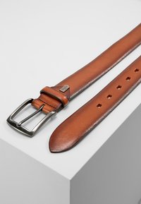 Cinturón de cuero marrón con un acabado suave, hebilla rectangular de metal en tono plateado y múltiples agujeros para ajuste de tamaño.