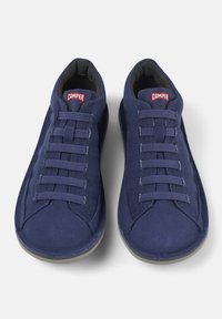 Navy blue shoes made of textured fabric with a smooth sole, featuring a lace-up design and a red "Camper" logo on the tongue.
