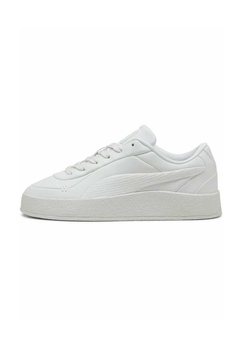 White sneaker with a smooth leather upper, textured accents, and a thick rubber sole. Features classic lacing and a rounded toe design.