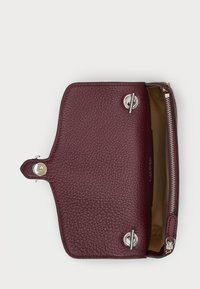 Burgundy leather wallet with a textured finish, silver hardware, and a zip closure. Interior features a beige lining and ample storage space.
