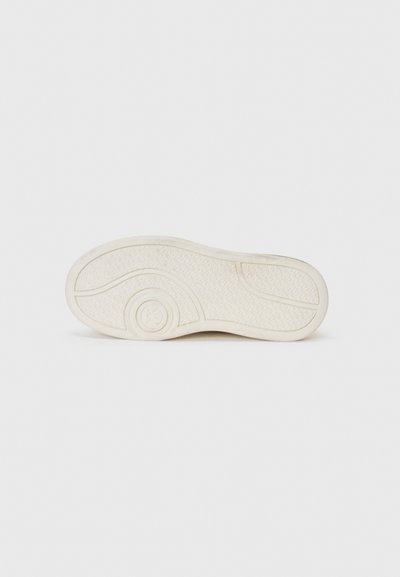 Suela de zapato de goma blanca con superficie texturizada, con diseño curvado y acento circular. Sin marcas de marca visibles.
