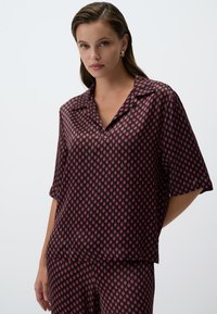 Rode en marineblauw geometrisch patroon blouse van lichtgewicht stof, met een kraag en korte mouwen, in een ontspannen pasvorm.