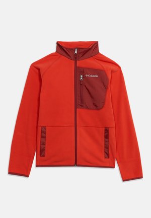 Veste polaire Columbia rouge vif à fermeture zippée, col, poche poitrine et finitions d’un rouge plus foncé. Manches longues, col montant et trois poches zippées.
