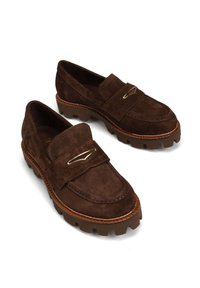 Brązowe zamszowe mokasyny o designie moccasin, z grubszą podeszwą i mosiężnymi detalami na wierzchu. Teksturowana powierzchnia z przeszyciami.