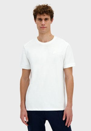 T-shirt en coton blanc à manches courtes, col rond, avec un petit logo embossé sur la poitrine. Texture lisse et coupe régulière.