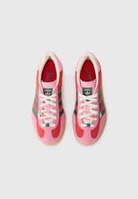 Rode en roze suède sneakers met witte veters, groene strepen en een kleine charm. Beschikt over een gemêleerde tong en een zachte rubberen zool.