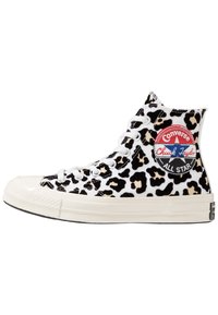 Zapatos Converse de caña alta que presentan una tela blanca con un estampado de leopardo en negro y marrón, cordones blancos y un parche rojo de Chuck Taylor en el costado.