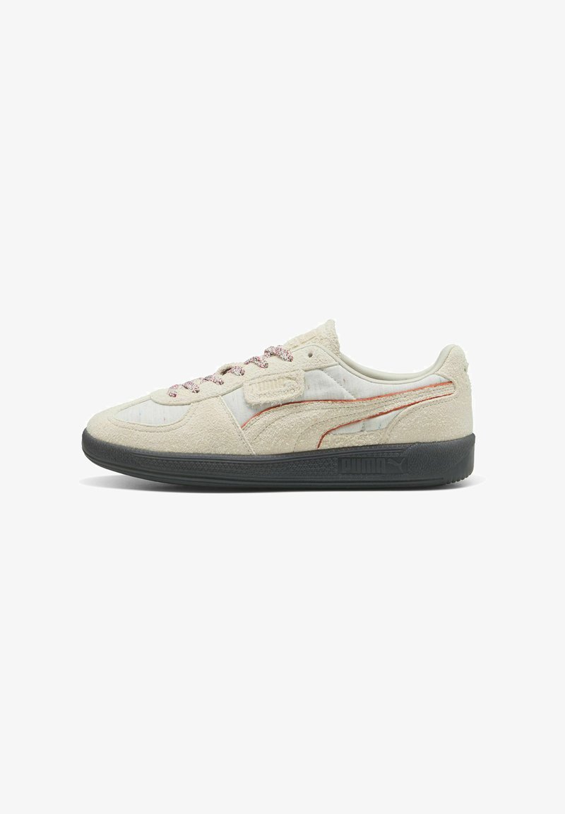 Sneakers z beżową teksturowaną cholewką, czerwonymi akcentami i cętkowanymi sznurowadłami. Posiadają czarną gumową podeszwę oraz klasyczne elementy wzornictwa.
