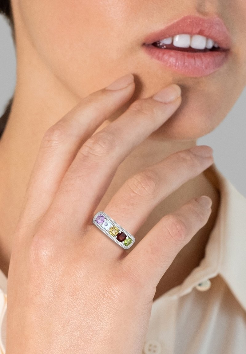 Rektangulær sølvringe med fem multifarvede ædelsten: lilla, blå, gul, rød og grøn, sat i en poleret fatning.