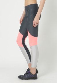 Leggings a vita alta con un mix di pannelli grigio scuro, rosa neon e argento. Realizzati in materiale elasticizzato con un design elegante e aderente.