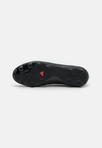Black soccer cleat sole with a textured surface, featuring six studs and a red accent on the heel. Marked with "COPA" branding.