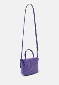 Fioletowa torebka faux leather z teksturowanym wzorem krokodyla, z górną rączką i długim regulowanym paskiem. Zamek klapowy.