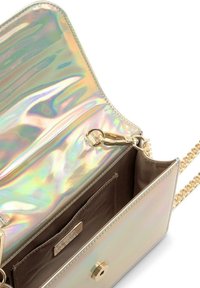 Bolso iridiscente con un brillo metálico, presenta una correa de cadena dorada, cierre de broche y un bolsillo interior marrón con una placa de logo.