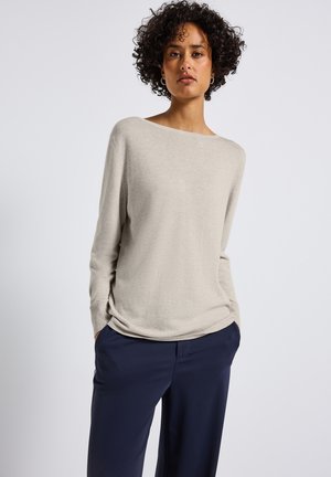 Helles beiges Sweatshirt mit weitem Ausschnitt, langen Ärmeln und gerippten Bündchen, kombiniert mit marineblauen Hosen und glatter Textur.