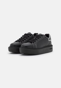 Sneaker nere con lacci, upper in pelle liscia, suola piatta in gomma, cuciture a contrasto e accenti grigi sul tallone.