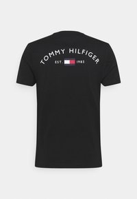 Camiseta de algodón negra con el texto "TOMMY HILFIGER" en blanco, con un logotipo rectangular y "EST. 1985" en la parte posterior. Mangas cortas, corte estándar.