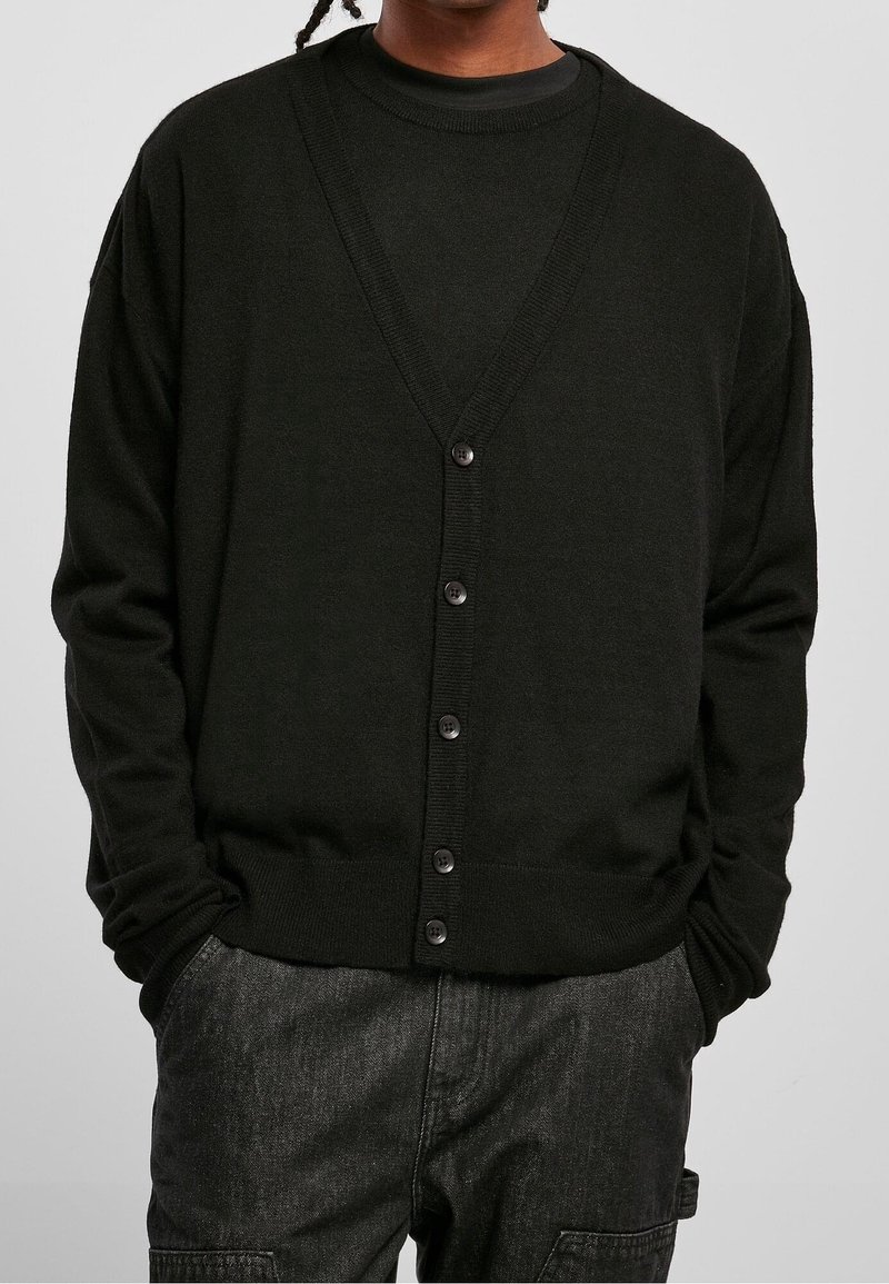 Czarny kardigan z dekoltem w kształcie litery V, długimi rękawami i zapięciem na guziki z przodu. Wykonany z miękkiego materiału o gładkiej strukturze.