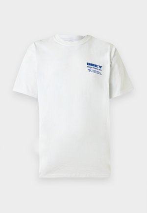 Biele tričko s krátkym rukávom, s okrúhlym výstrihom a modrým nápisom "OBEY Sound Design Dept" a malou grafikou na ľavej strane hrude.