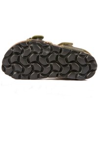 Semelle de chaussure en caoutchouc noire avec un motif en vagues, présentant des sangles vertes et un design en camouflage sur la partie supérieure.
